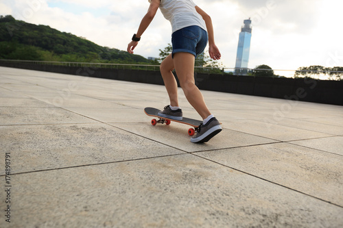 Woman practicing with skateboard at city