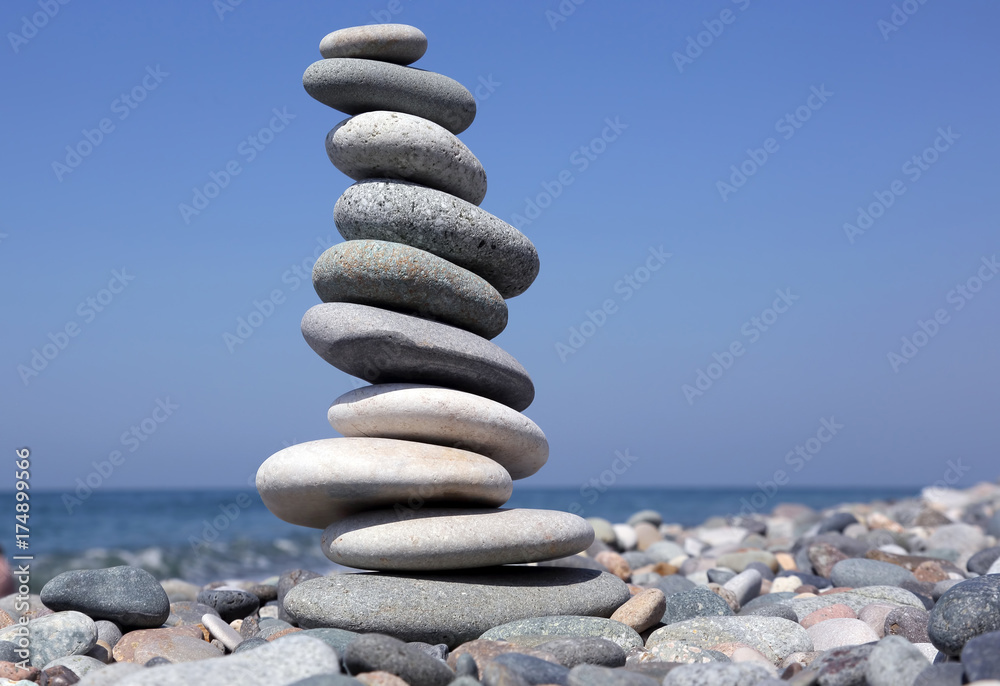 balance a pyramid of smooth stones on the background of the sea. balance a pyramid of smooth stones on the background of the sea.