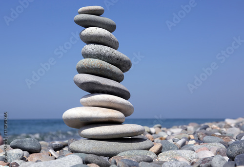 balance a pyramid of smooth stones on the background of the sea.