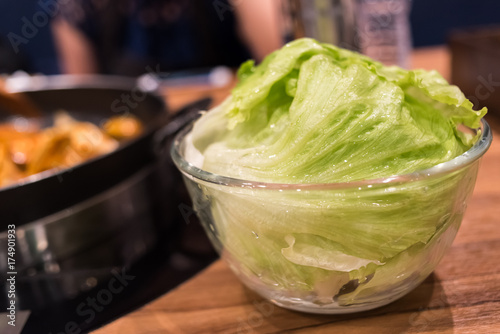 Fresh lettuce leaves in glass bowl, close up.