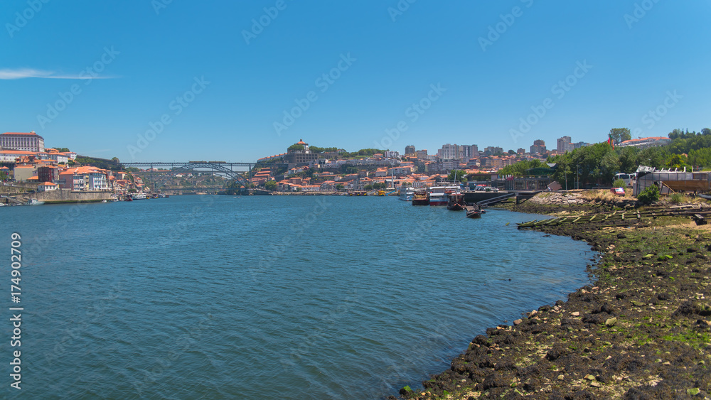 Porto, Portugal, panorama of Dom Luis bridge in background, the river Douro and tiles roofs 
