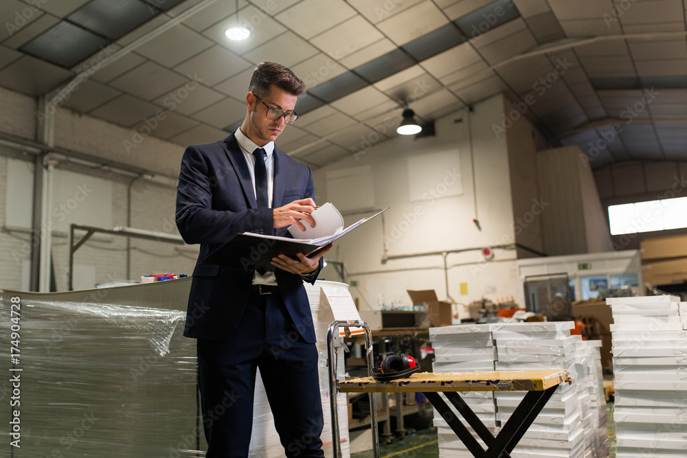 Inspector checking documents in factory Stock-Foto | Adobe Stock