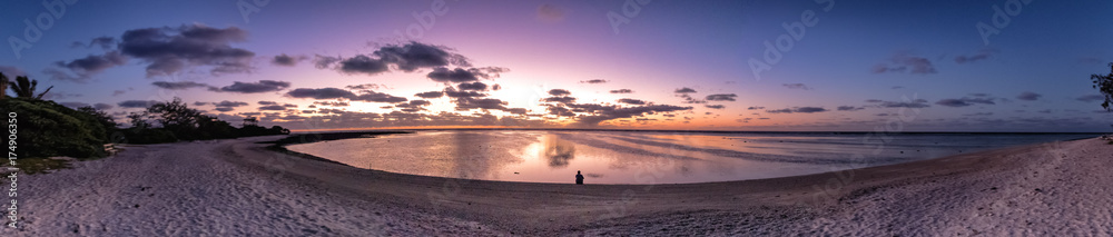 Panoramic sunrise over the coral reef on Lady Elliot Island with a person in the middle looking at the reef