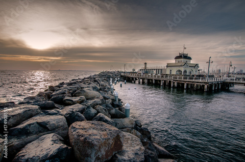 St kilda Pier and kiosk in Melbourne Australia at dusk on a cloudy day.