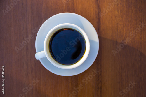 Cup of coffee on wooden table. Top view