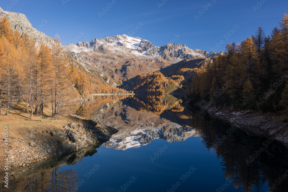 Scenics dam lake landscape with clear reflection on mountain in sunny autumn fall day outdoor.