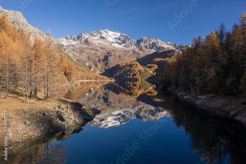 Scenics dam lake landscape with clear reflection on mountain in sunny autumn fall day outdoor.