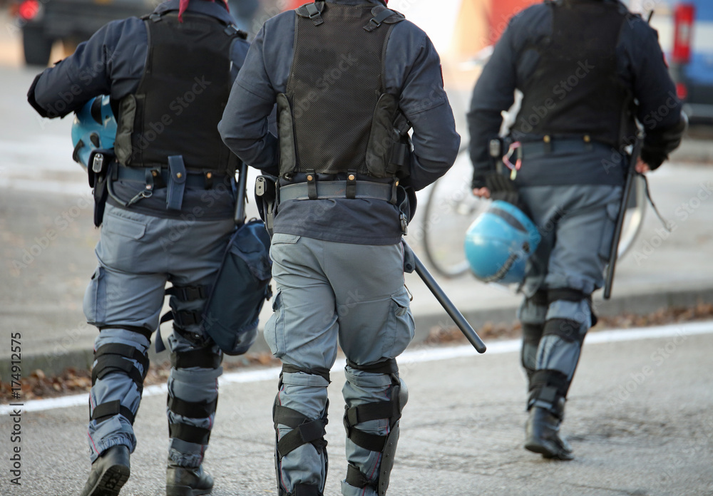 three policemen with anti-bulletproof jacket in anti-riot unifor three policemen with anti-bulletproof jacket in anti-riot unifor