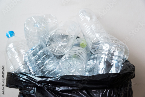 Plastic bottles in black garbage bags waiting to be taken to recycle.