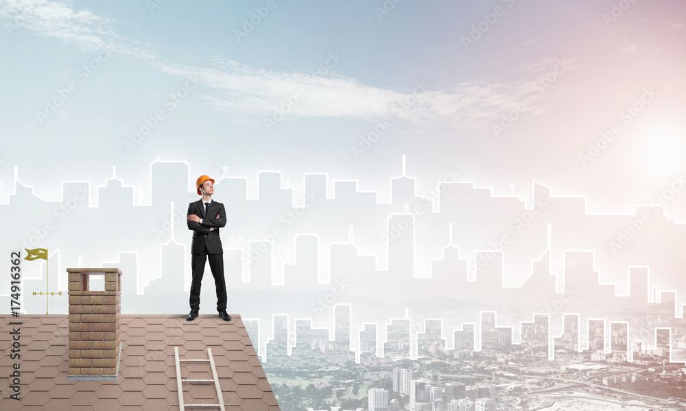 Engineer man standing on roof and looking away. Mixed media Engineer man standing on roof and looking away. Mixed media