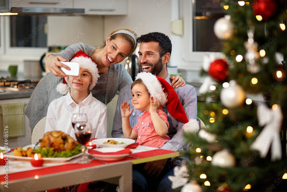 Family taking selfie at decorated Christmas table Family taking selfie at decorated Christmas table