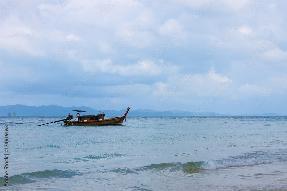 Fishing boat in the open sea against the backdrop of the mountains