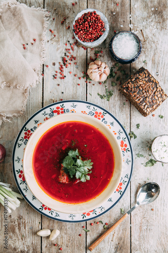 borscht with dill and parsley,with bread and spices on wooden background