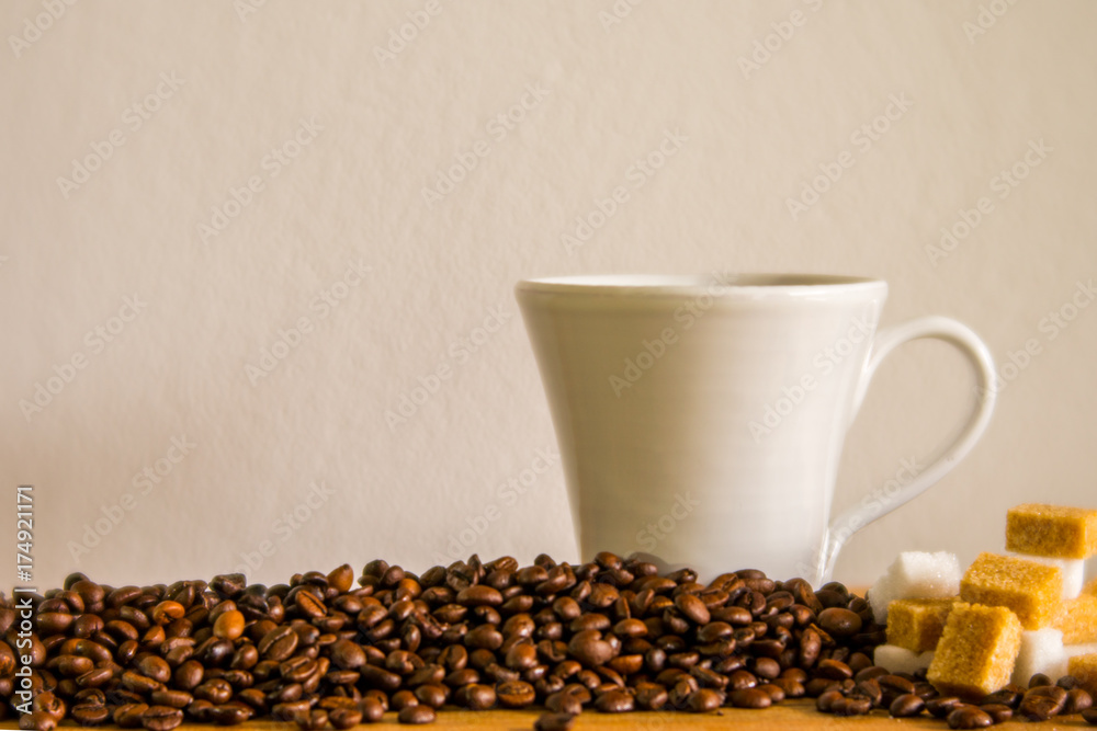 Naklejka premium white coffee mug and coffee beans with sugar cubes