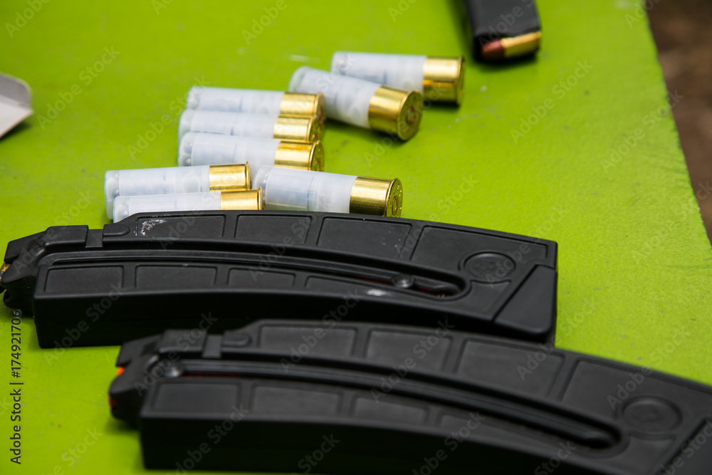 shotgun shells and mazine on green table shotgun shells and mazine on green table