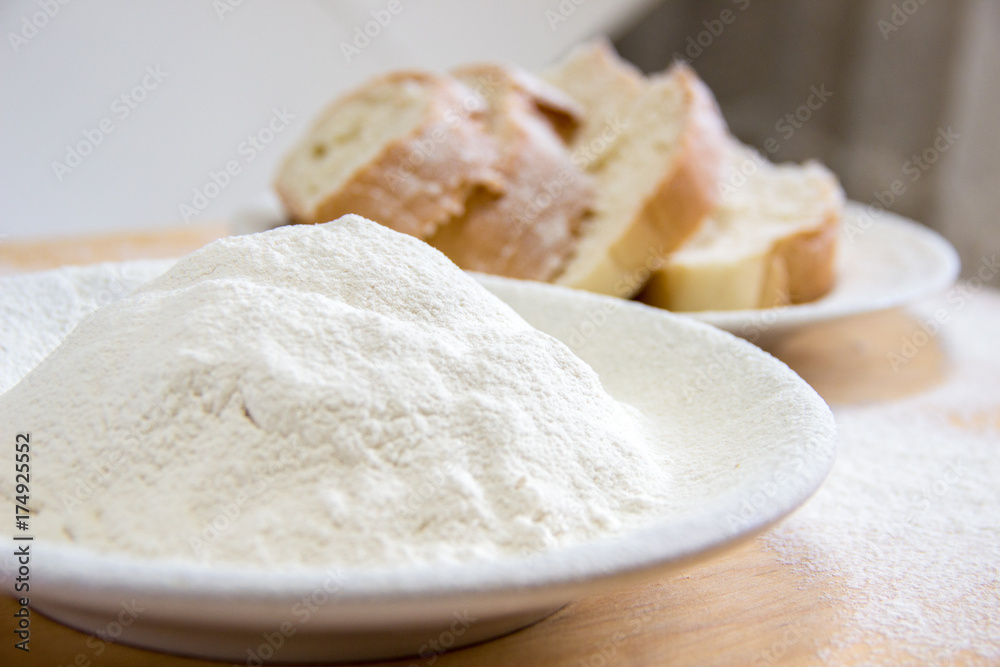 Slices of bread and wheat flour in a white plate on the table