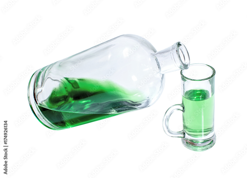 Bottle and glass filled with green strong drink Bottle and glass filled with green strong drink
