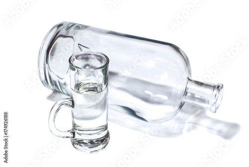 Bottle and small glass filled with transparent strong drink