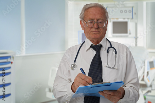 Portrait of an old senior experienced male doctor with a stethoscope in hospital. Health care and medical concept.