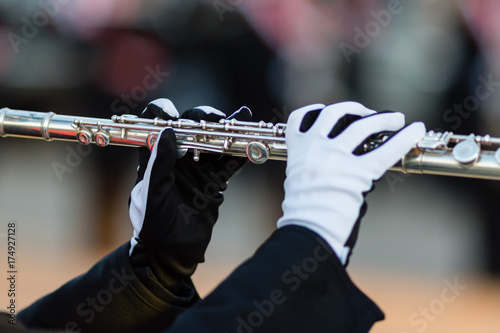 gloved hands of a flute player in a marching band