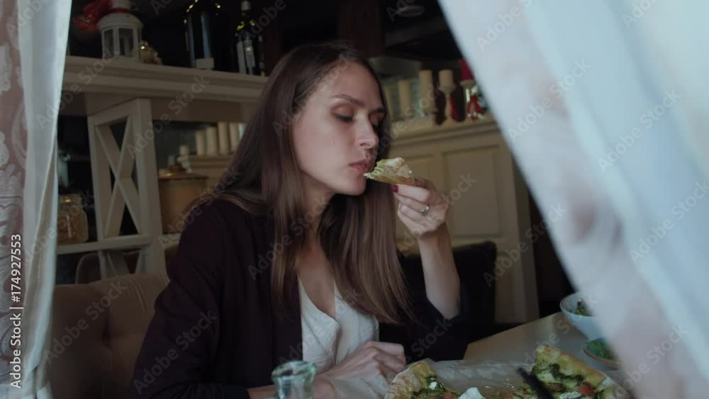 Beautiful young woman eating pizza in the restaurant. Happy and joyful lifestyle. pours oil pizza Beautiful young woman eating pizza in the restaurant. Happy and joyful lifestyle. pours oil pizza