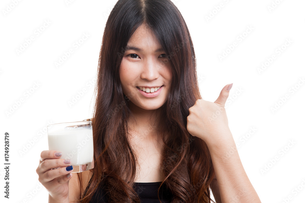 Healthy Asian woman drinking a glass of milk thumbs up. Healthy Asian woman drinking a glass of milk thumbs up.