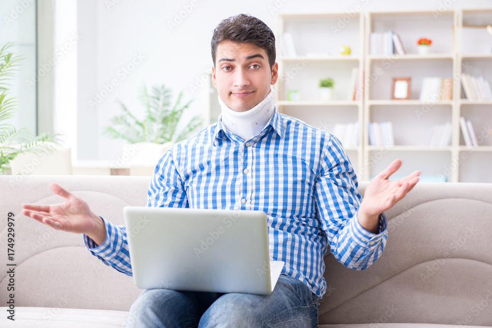 Man freelancer in a cervical collar neck brace working from home