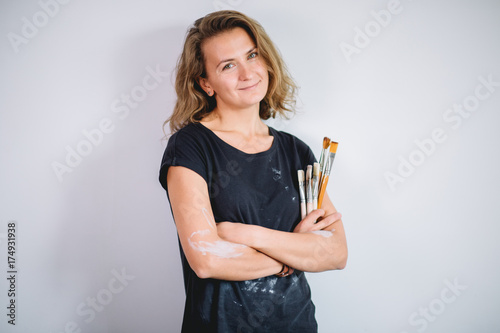Woman painting clay pot with senior potter at workshop photo