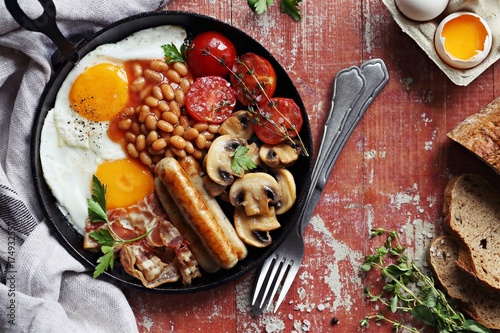 Traditional english breakfast. Pan with full english breakfast overhead rustic wooden table. Overhead view. photo
