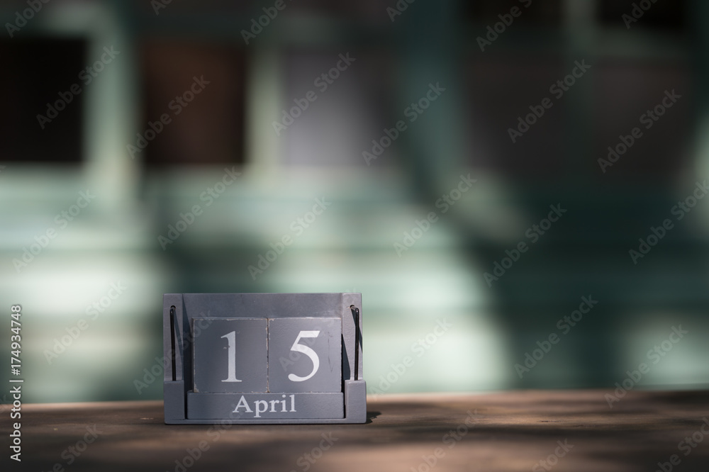 April 15th. Tax Day. Image of april 15 wooden color calendar on wooden table background. Spring day, empty space for text