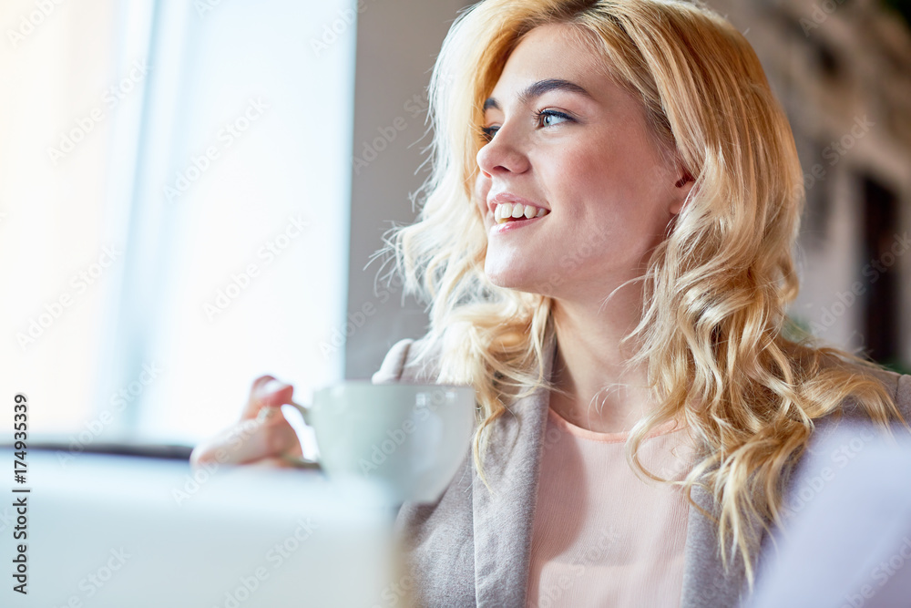Young woman with cup of tea enjoying leisure in cafe Young woman with cup of tea enjoying leisure in cafe