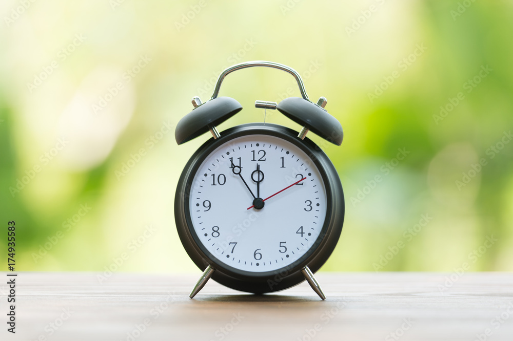 Retro alarm clock with five minutes to twelve o'clock. Retro alarm clock with five minutes to twelve o'clock.