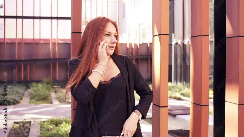 Angry woman talking on cellphone in the city.
Angry woman talking on cellphone in the city.