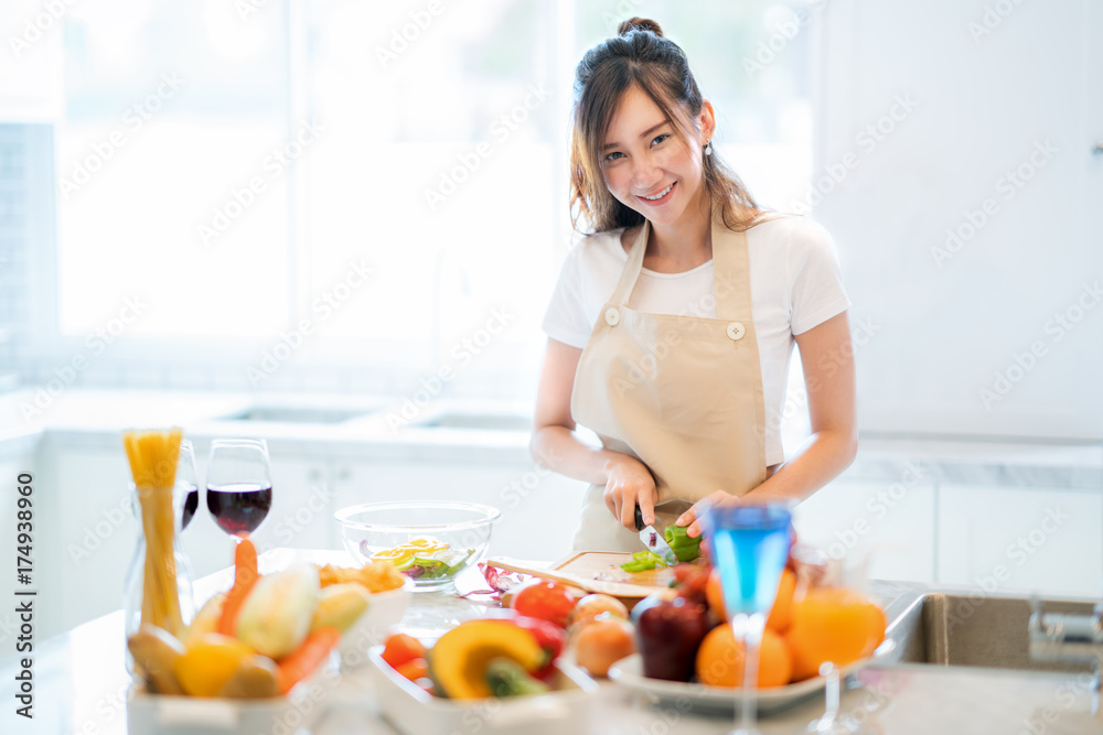 Asian wife prepare salad and spaghetti for parrty dinner in kitchen room