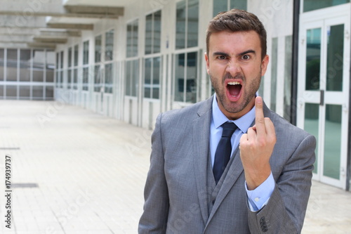 Foto Moody businessman showing a middle finger