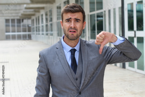 Fotografie Sad businessman showing a thumbs down
