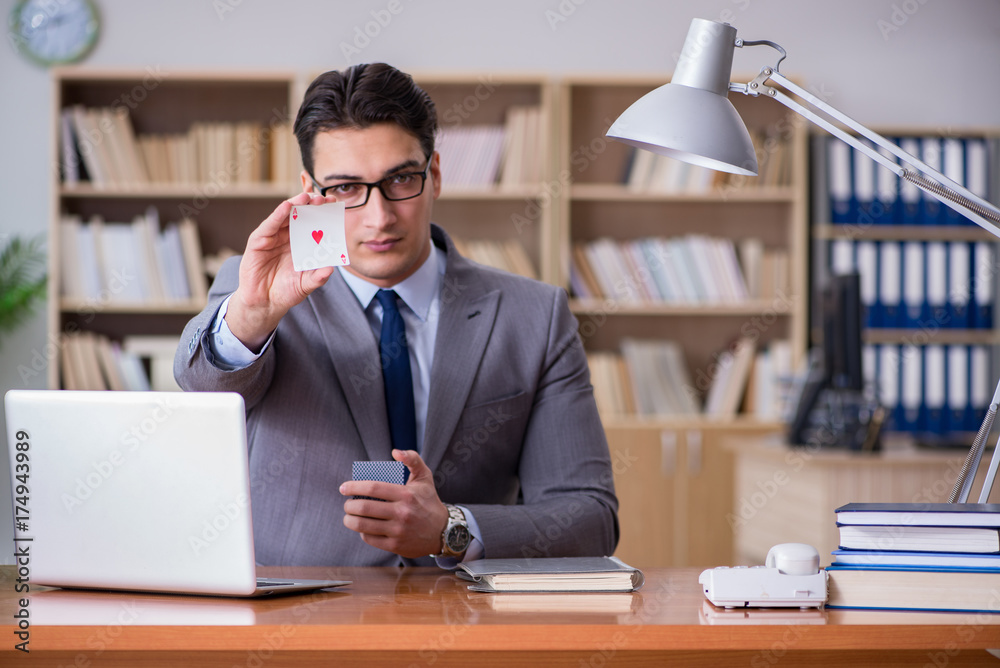 Businessman gambling playing cards at work Businessman gambling playing cards at work