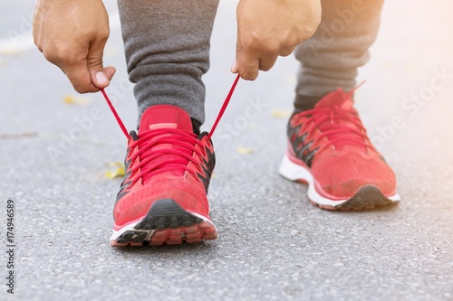 Running shoes. Barefoot running shoes closeup. male athlete tying laces for jogging on road. Runner ties  getting ready for training. Sport lifestyle.