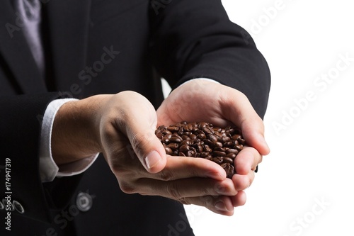 Coffee beans in hands on white background