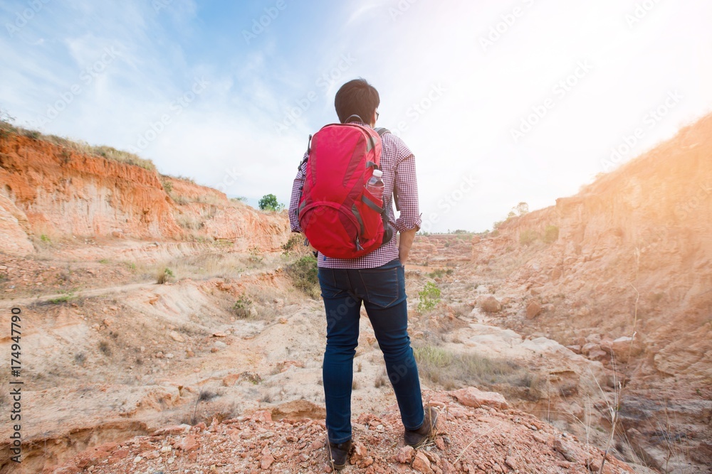 Young travel red backpack enjoying a looking at Mountain abyss , Panoramic view. Traveling along , active lifestyle concept. Young travel red backpack enjoying a looking at Mountain abyss , Panoramic view. Traveling along , active lifestyle concept.