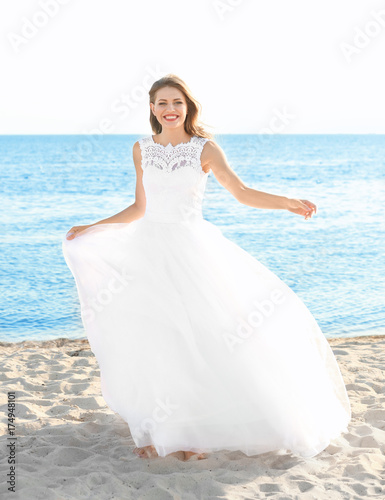 Happy young bride on sea beach