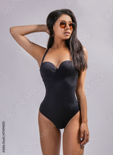 Beautiful young woman in swimming suit on light background © Africa Studio