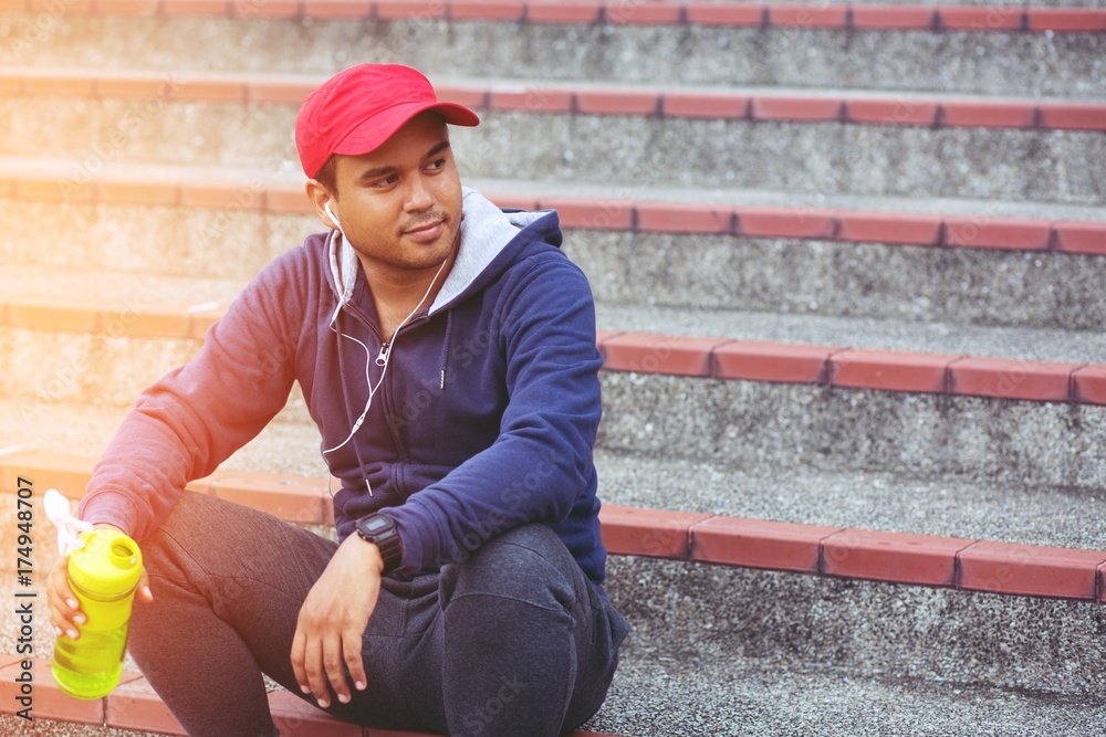 Young man sit break drinking water after running Jogging workout. Thirsty healthy male with fit body drinking water. Young man sit break drinking water after running Jogging workout. Thirsty healthy male with fit body drinking water.