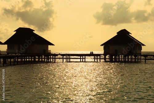 Silhouette couple enjoy the moment at water villa in Maldives during sunset