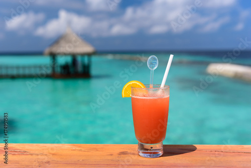 Fresh orange juice welcome drink at resort in maldive with background of beautiful ocean.