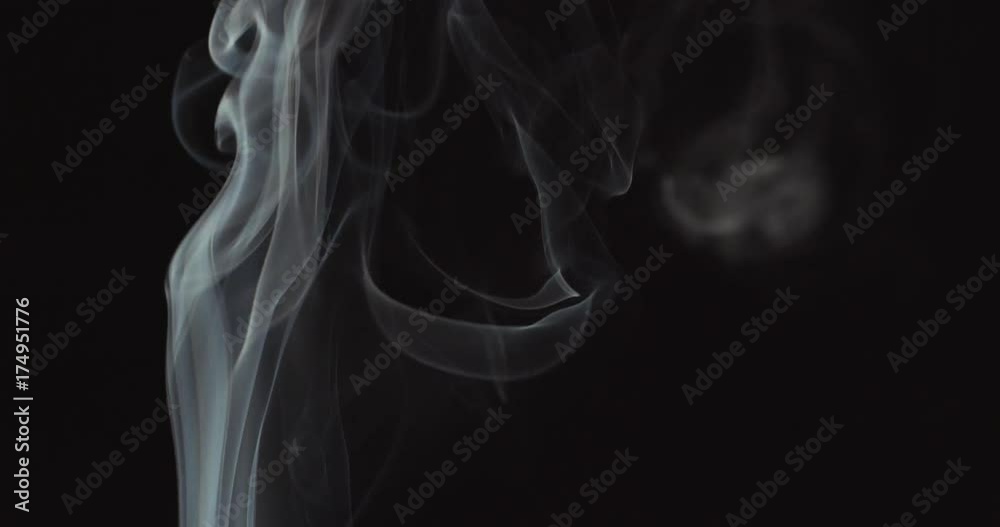 Candle blown out and white smoke rising up on black background