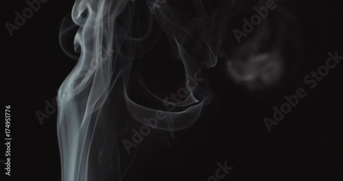 Candle blown out and white smoke rising up on black background photo