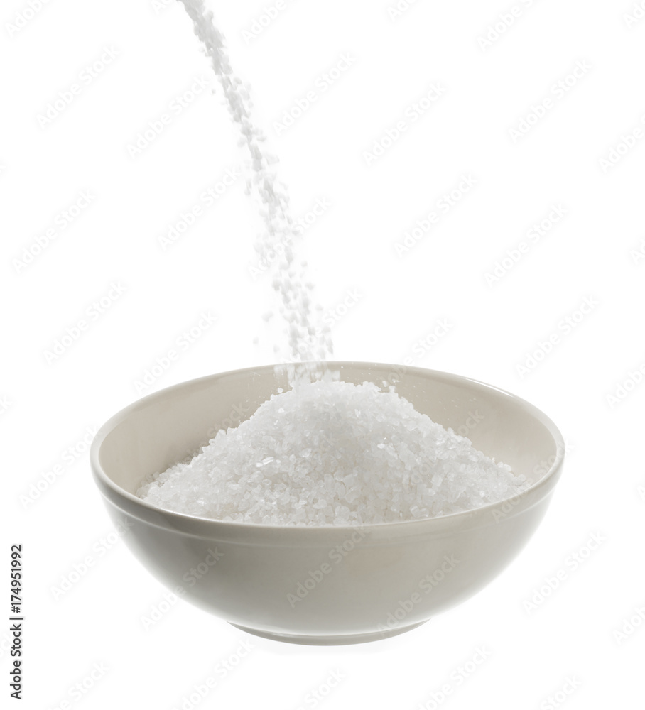 Pouring sea salt in porcelain bowl isolated on white background. Pouring sea salt in porcelain bowl isolated on white background.