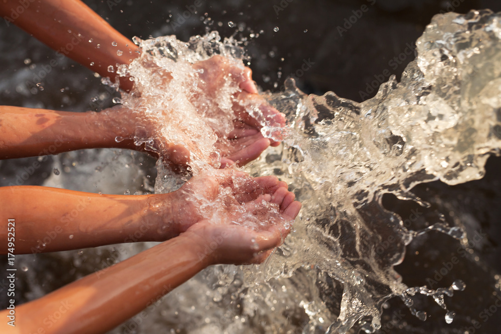 Fototapeta premium Water flowing in to children hand, Water conservation, ecology and environment concept.