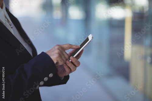 Midsection of businesswoman using mobile phone